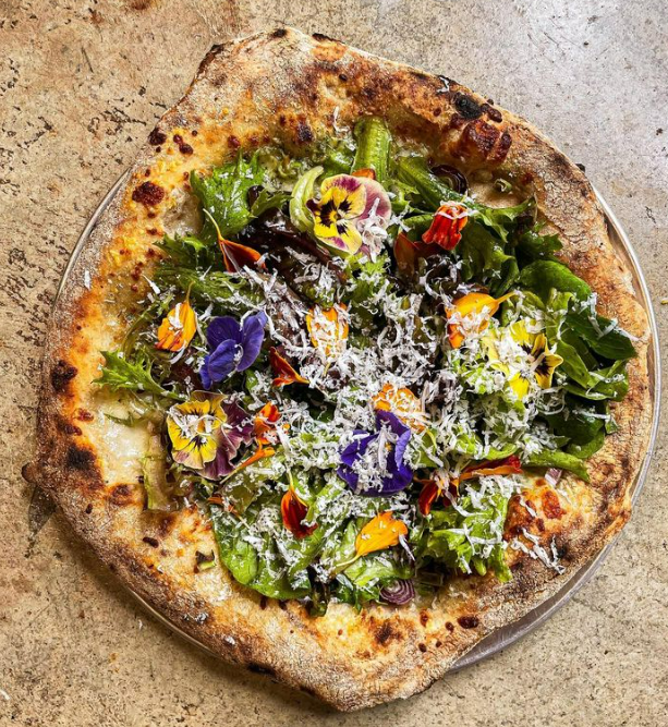 Salita Pizza's salad pizza features spring onions, salad greens and flowers from a local farm.