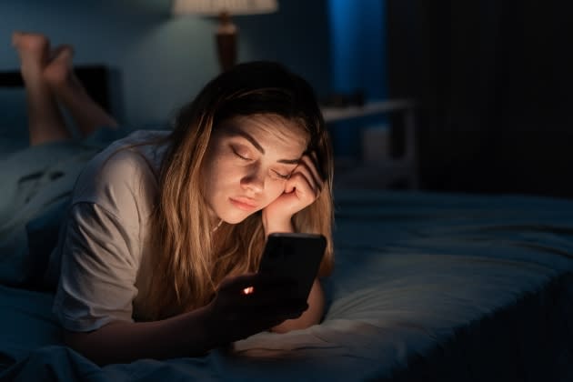 end-of-dating-apps.jpg Addicted to social media young woman falling asleep with smartphone at night in bed. Mobile use addiction - Credit: Adobe Stock