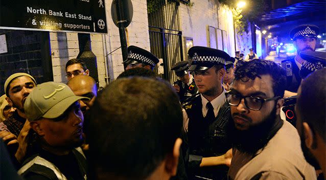 Police and civilians gather in front of the mosque after the attack. Photo: AP