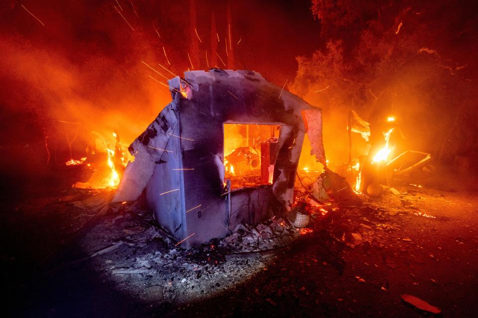 Flames from the LNU Lightning Complex Fire consume a home in unincorporated Napa County, Calif., on Aug. 19.