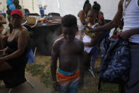 Emmett Palmer, right sprays sunscreen on Iron Grim, 6, as tenants gather for a birthday party at the Nickerson Gardens housing project in the Watts neighborhood of Los Angeles, Wednesday, June 10, 2020. (AP Photo/Jae C. Hong)