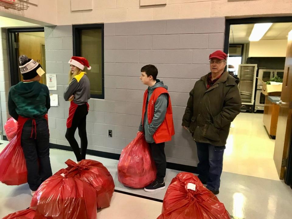 Volunteers wait to load bags into people's cars for the Salvation Army's annual distribution day on Wednesday, Dec. 22, 2021.