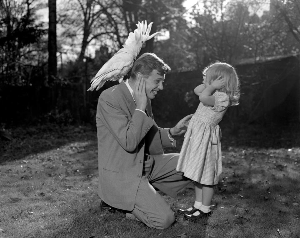 Cover your ears: Sir David Attenborough with his three-year-old daughter Susan, as they cover their ears while sulphur-crested cockatoo Georgie lets out a piercing shriek in 1957 (PA)