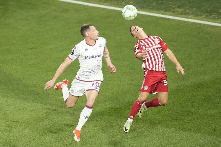 Olympiacos' Daniel Podence, right, jumps for a header with Fiorentina's Andrea Belotti during the Conference League final soccer match between Olympiacos FC and ACF Fiorentina at OPAP Arena in Athens, Greece, Wednesday, May 29, 2024. (AP Photo/Petros Karadjias)