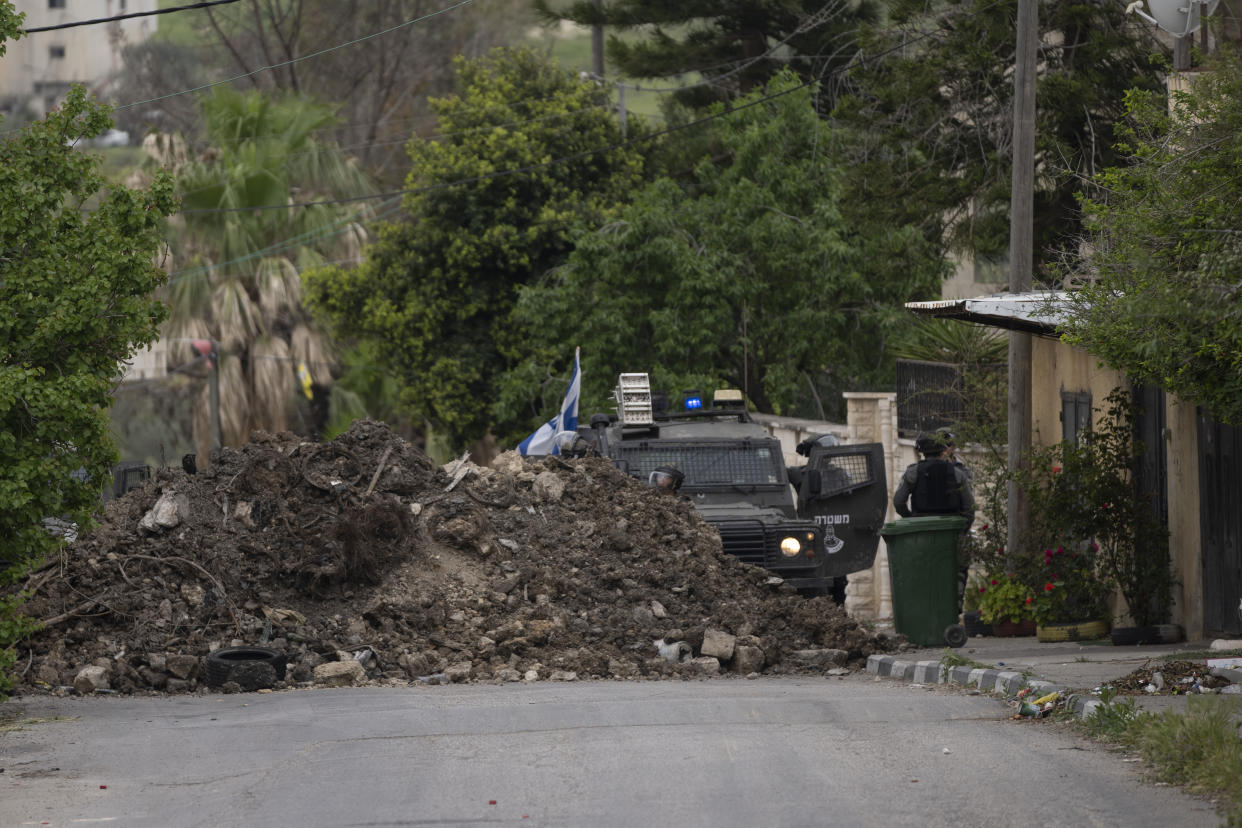 Israeli border police use a mound of earth to close the main entrance of the West Bank village of Burqa, north of Nablus, Tuesday, April 19, 2022. Palestinians protesting against a settlers march toward Homesh, a settlement that was officially dismantled by Israel in 2005, clashed with Israeli border police that closed the main entrance of the village to secure the event. (AP Photo/Nasser Nasser)