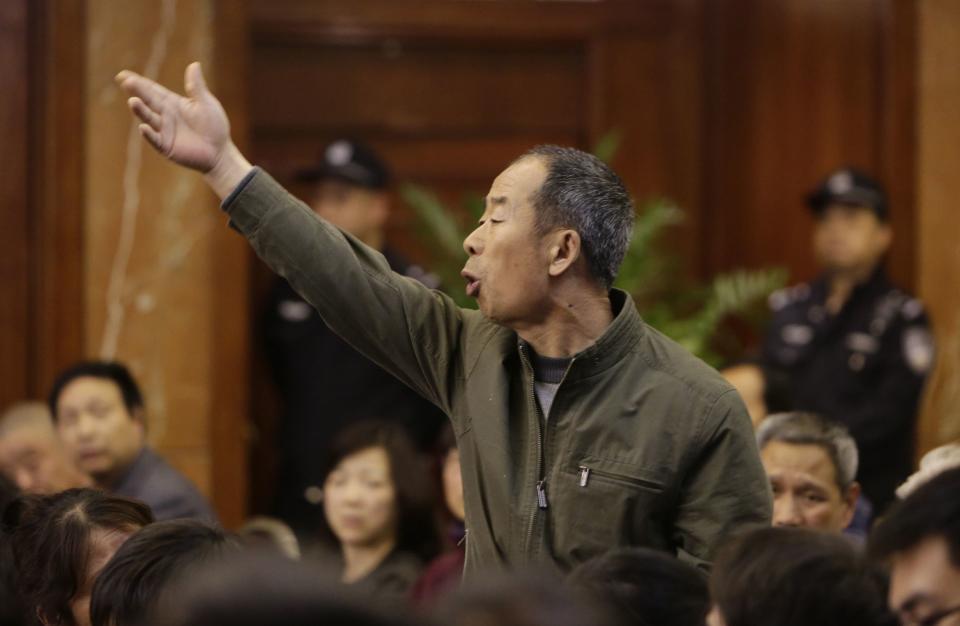 A relative of a passenger aboard Malaysia Airlines flight MH370 gestures as he shouts at Malaysian representatives during a briefing at Lido Hotel in Beijing