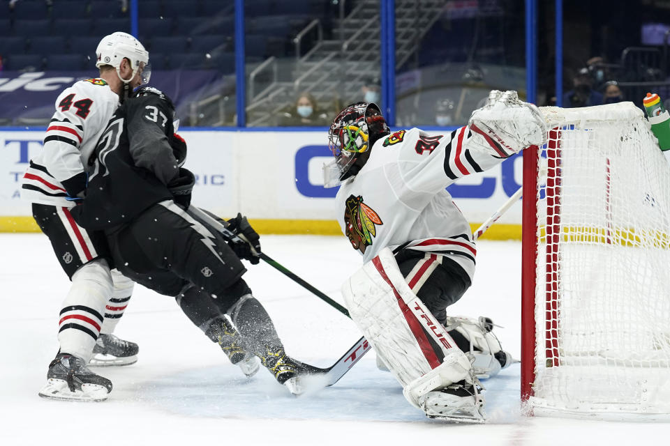 Tampa Bay Lightning center Yanni Gourde (37) puts the puck past Chicago Blackhawks goaltender Malcolm Subban (30) for a goal during the second period of an NHL hockey game Saturday, March 20, 2021, in Tampa, Fla. Defending for Chicago is defenseman Calvin de Haan (44). (AP Photo/Chris O'Meara)