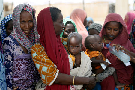 FILE PHOTO: Women wait with their children under a shed for food rations at an internally displaced persons (IDP) camp on the outskirts of Maiduguri, northeast Nigeria June 6, 2017. REUTERS/Akintunde Akinleye/File Photo