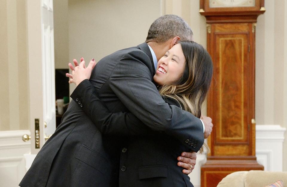 President Barack Obama gives a hug to Dallas nurse Nina Pham in the Oval Office of the White House on October 24, 2014 in Washington, DC. Pham, a nurse who was infected with Ebola from treating patient Thomas Eric Duncan at Texas Health Presbyterian Hospital in Dallas and was first diagnosed on October 12, was declared free of the virus.