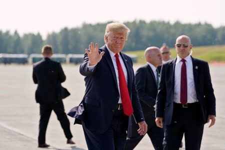 U.S. President Donald Trump waves during a refueling stop at Joint Base Elmendorf, Alaska, U.S. on his way to the G-20 Summit in Osaka