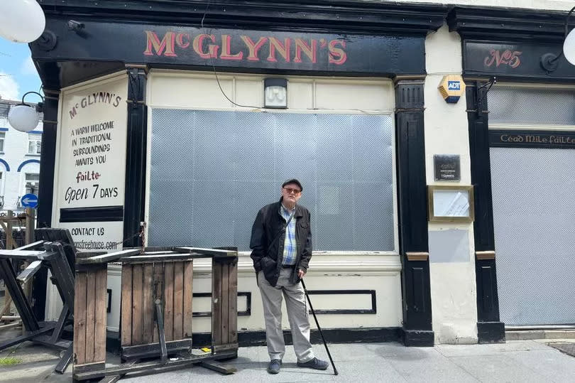 Dave stood outside the boarded McGlynn's pub where he worked for 17 years