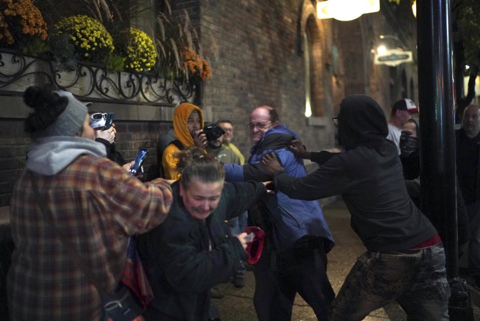 A Trump supporter got in a fight with a protester after his hat was grabbed off his head outside the Target Center after President Donald Trump visited Minneapolis, for a campaign rally on Thursday, Oct. 10, 2019. (Renee Jones Schneider/Star Tribune via AP)