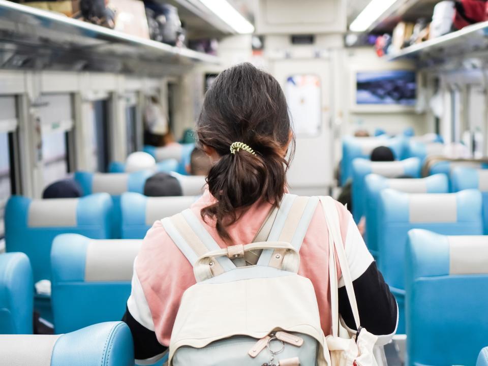 Woman walking to her seat on a train.