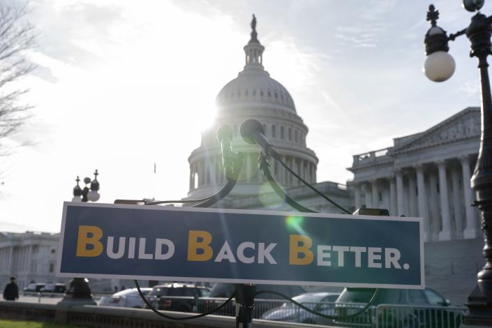 A sign saying Build Back Better is set in front of the Capitol building.