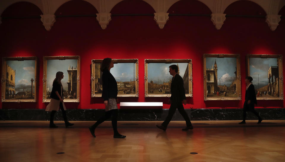 People walk past Canaletto’s paintings of Venice