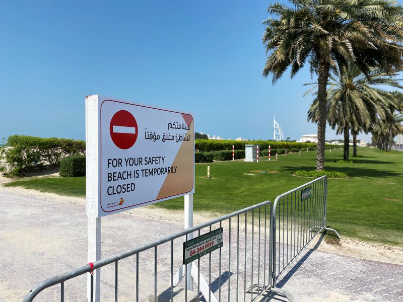 A sign board is seen at the entrance of an empty beach, after a curfew was imposed to prevent the spread of the coronavirus disease (COVID-19), in Dubai