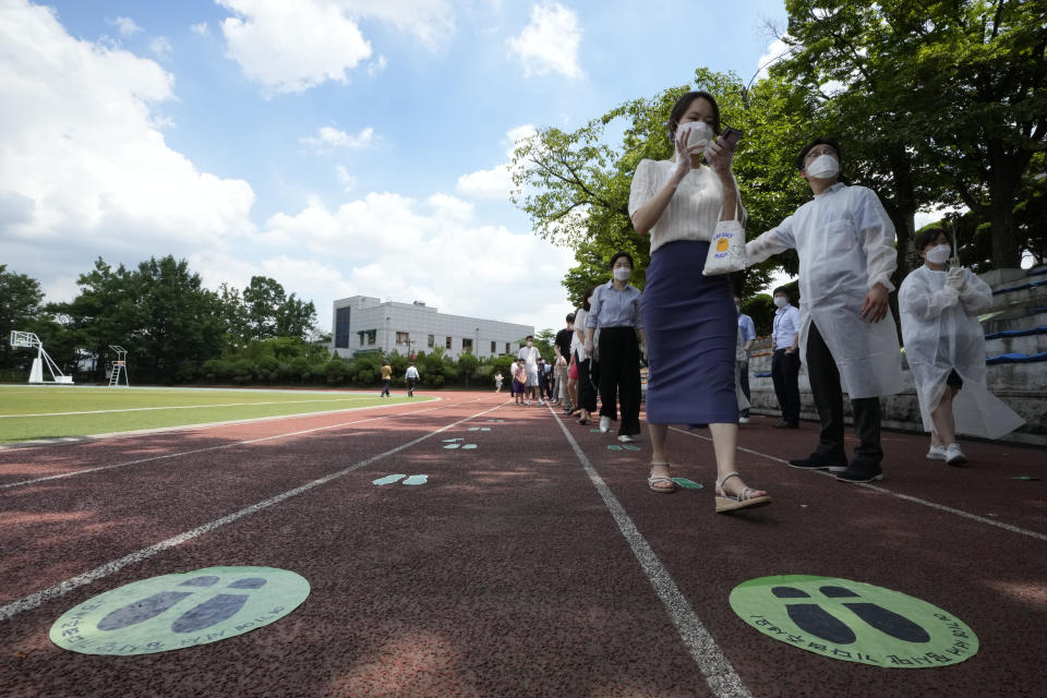 People queue in line to wait for the coronavirus testing at a makeshift testing site at the National Assembly in Seoul, South Korea, Thursday, July 15, 2021. South Korea has added 1,600 more coronavirus cases, with infections spreading beyond the hard-hit capital area where officials have enforced the country's toughest social distancing restrictions. (AP Photo/Ahn Young-joon)