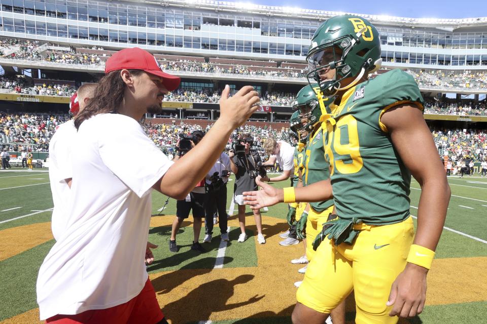 Utah quarterback Cameron Rising, left greets Baylor tight end Drake Dabney at the coin toss before an NCAA college football game, Saturday, Sept. 9, 2023, in Waco, Texas. (AP Photo/Jerry Larson | AP