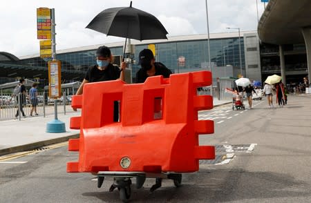 Protesters build barricades outside the terminals at Hong Kong International Airport