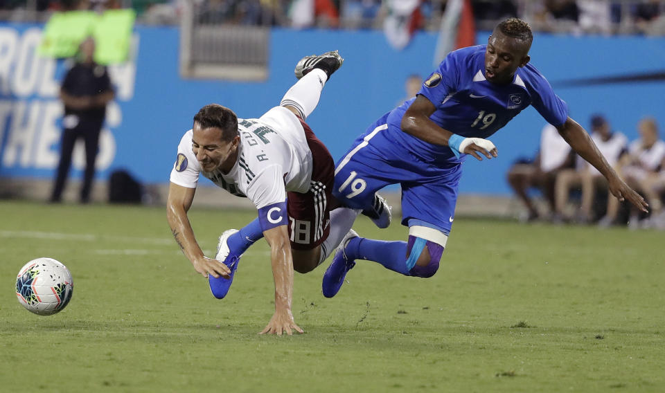 Mexico's Andres Guardado (18) and Martinique's Daniel Herelle (19) battle for the ball during the first half of a CONCACAF Golf Cup soccer match in Charlotte, N.C., Sunday, June 23, 2019. (AP Photo/Chuck Burton)