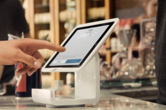 A person using a Square Stand point-of-sale system.