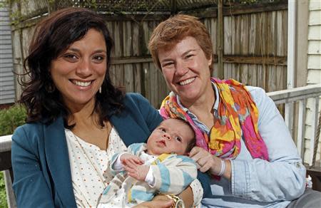 Valeria Tanco (L), and Sophy Jesty pose with their new baby girl, Emilia, at their home in Knoxville, Tennessee April 7, 2014. REUTERS/Wade Payne