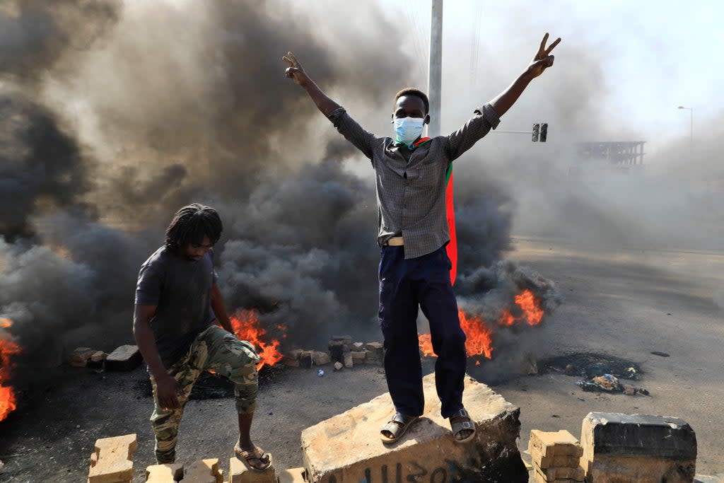 Protesters burn tyres to block a road in the capital Khartoum on Monday, denouncing overnight detentions by the army of members of Sudan’s government  (AFP/Getty)