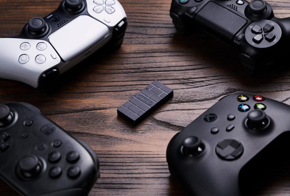 8bitdo wireless adapter 2 surrounded by xbox, ps5  and ps4 controllers