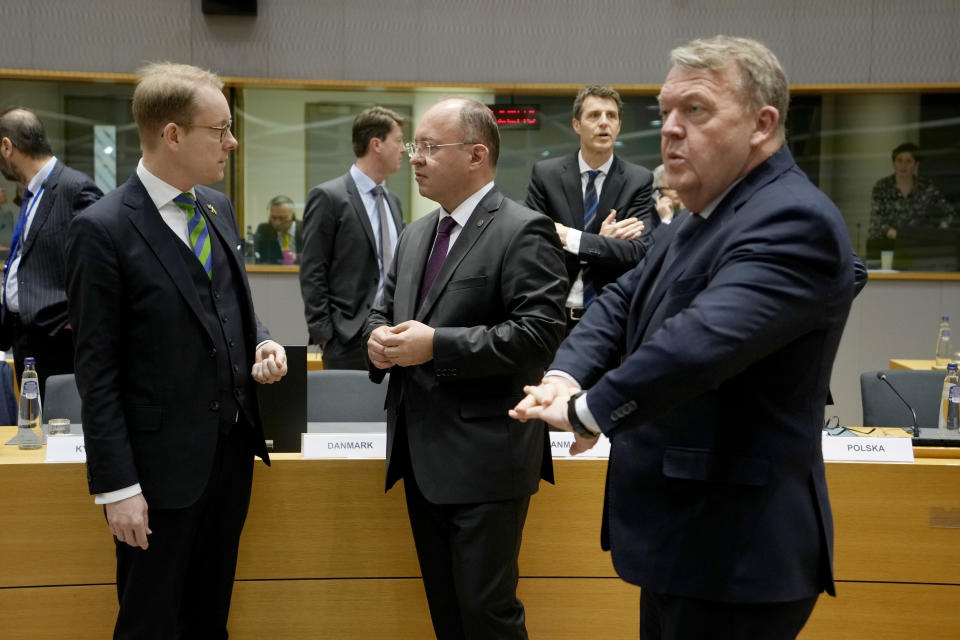 Sweden's Foreign Minister Tobias Billstrom, left, speaks with Romania's Foreign Minister Bogdan Aurescu, center, and Denmark's Foreign Minister Lars Lokke Rasmussen during a meeting of EU foreign ministers at the European Council building in Brussels on Monday, March 20, 2023. European Union foreign ministers on Monday will discuss the situation in Ukraine and Tunisia. (AP Photo/Virginia Mayo)
