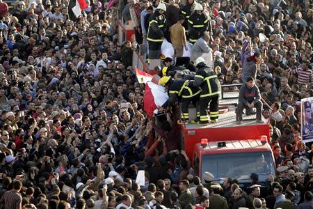 Mourners surge in a crowd towards a vehicle carrying wrapped bodies during a funeral service for policemen and people killed in a car bomb explosion, near Al Naser Mosque in Egypt's Nile Delta city of Mansoura in Dakahlyia province in this December 24, 2013 file photo. REUTERS/Mohamed Abd El Ghany/Files