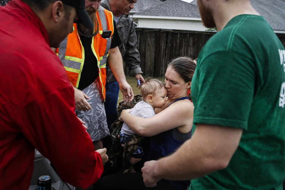 <em>Lauren Durst holds onto her ten-month-old son, Wyatt Durst, as they evacuate from the Savannah Estates neighbourhood as Addicks Reservoir nears capacity (AP)</em>