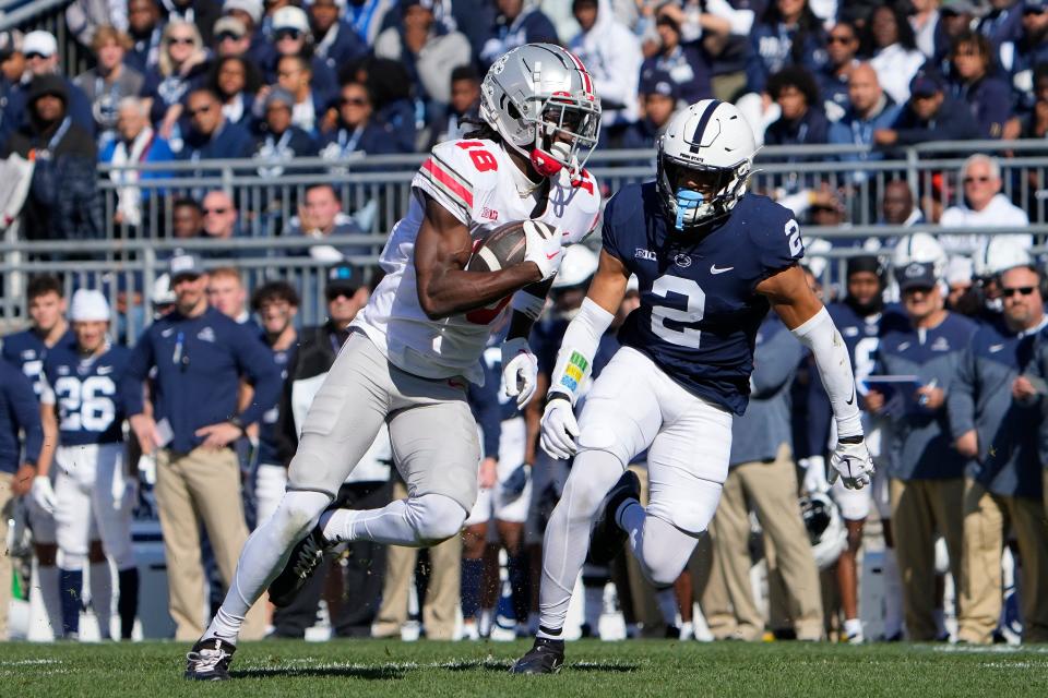 Oct 29, 2022; University Park, Pennsylvania, USA; Ohio State Buckeyes wide receiver Marvin Harrison Jr. (18) runs past Penn State Nittany Lions safety Keaton Ellis (2) after making a catch during the first half of the NCAA Division I football game at Beaver Stadium. Mandatory Credit: Adam Cairns-The Columbus Dispatch