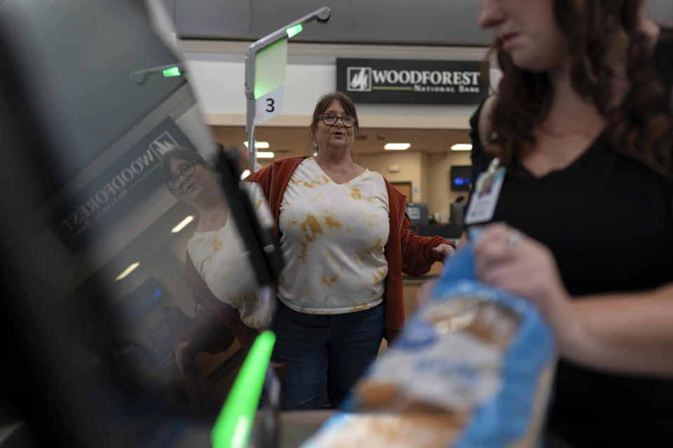 Jodi Ferdinandsen looks to Family Resource Center peer support worker Jesse Johnson as she helps her check out at Walmart in Findlay, Ohio, Thursday, Oct. 12, 2023. Peer support workers help people in early recovery in a variety of ways. (AP Photo/Carolyn Kaster)