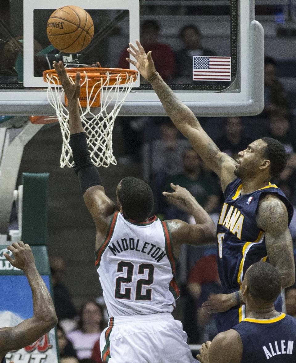 Milwaukee Bucks' Khris Middleton (22) shoots the ball over Indiana Pacers' Rasual Butler during the second half of an NBA basketball game on Wednesday, April 9, 2014, in Milwaukee. (AP Photo/Tom Lynn)
