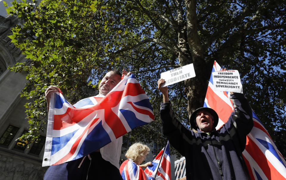 Demonstrators hold placards and flags outside the Supreme Court in London, Wednesday, Sept. 18, 2019. The Supreme Court is set to decide whether Prime Minister Boris Johnson broke the law when he suspended Parliament on Sept. 9, sending lawmakers home until Oct. 14 — just over two weeks before the U.K. is due to leave the European Union. (AP Photo/Kirsty Wigglesworth)