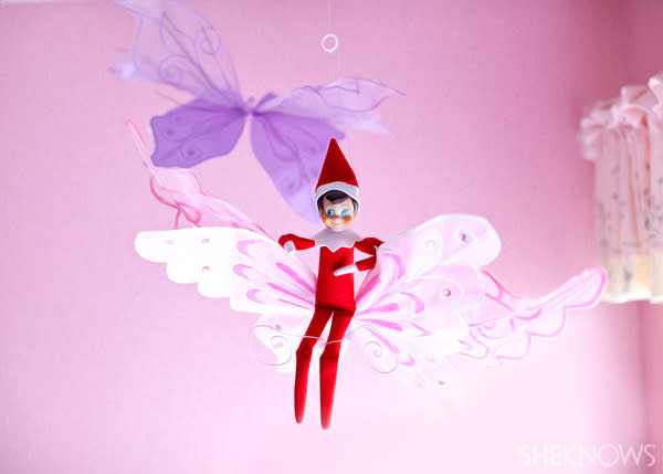 Elf on the Shelf idea 2: Elfie Rojo sitting on a butterfly decoration