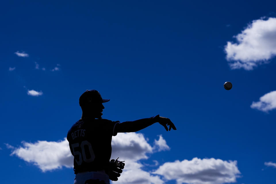 Los Angeles Dodgers second baseman Mookie Betts warms up before a spring training baseball game against the Colorado Rockies in Phoenix, Sunday, March 3, 2024. (AP Photo/Ashley Landis)