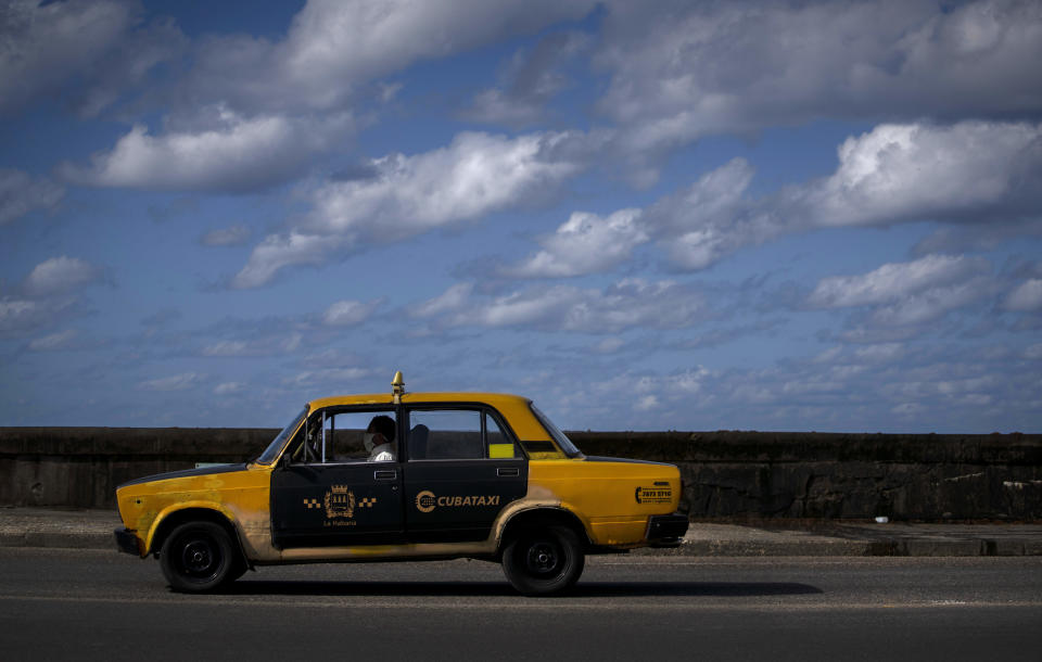 A Soviet-era Lada taxi cab drives along the Malecon in Havana, Cuba, Monday, March 22, 2021. When Ladas arrived in Cuba they were turned into taxis by the thousands. (AP Photo/Ramon Espinosa)