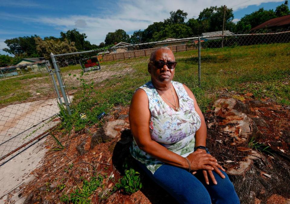 Barbara Glover, de 65 años, posa en el lugar donde solía estar su casa, el viernes 22 de septiembre de 2023, en la zona de Ybor City de Tampa. La casa de Glover resultó dañada tras caerle encima un árbol durante el huracán Ian el año pasado.