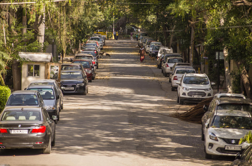 NEW DELHI, INDIA - MARCH 26: A woman walks amid vehicles parked on a street during, as nationwide lockdown continues over highly contagious novel coronavirus on March 26, 2020 in New Delhi, India. India is under a 21-day lockdown to fight the spread of Covid-19 infections and while the security personnel on the roads are enforcing the restrictions in many cases by using force, the workers of country's unorganized sector are bearing the brunt of the curfew-like situation. According to the international labour organisations India's 90% workforce is employed in the informal sector and most do not have access to pensions, sick leave, paid leave or any kind of insurance. Reports on Thursday said that Prime Minister Narendra Modi's government is preparing a massive bailout to reach to the underprivileged sections of the country and will hand over the dole through direct cash transfers. (Photo by Yawar Nazir/Getty Images)