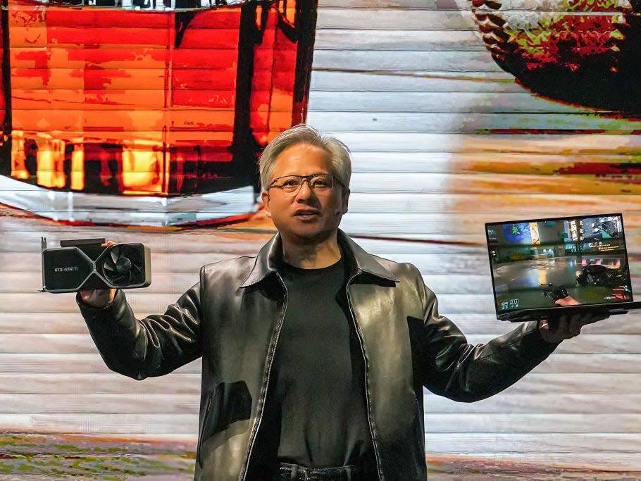 Nvidia President and CEO Jensen Huang holds an NVIDIA 4060Ti graphics card and a laptop at a keynote presentation at Computex, or the Taipei International Information Technology Expo, on May 29, 2023.