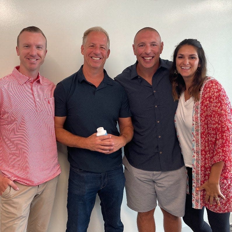 Tyler and Eric Goodwin, of Goodwin Family Management, pose for a photo with Mike and Stephanie Oliveira. Goodwin Family Management has purchased the Oliveiras' Donut Love.
