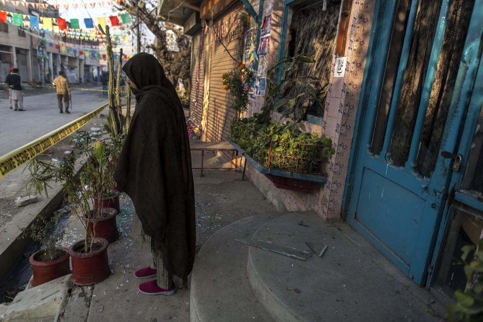 A woman stands beside the cordon at the site of a suicide blast in Rawalpini