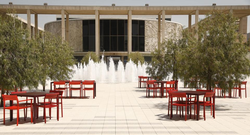 A view of the Music Center plaza shows a fountain and tables in the foreground, with the Mark Taper Forum beyond