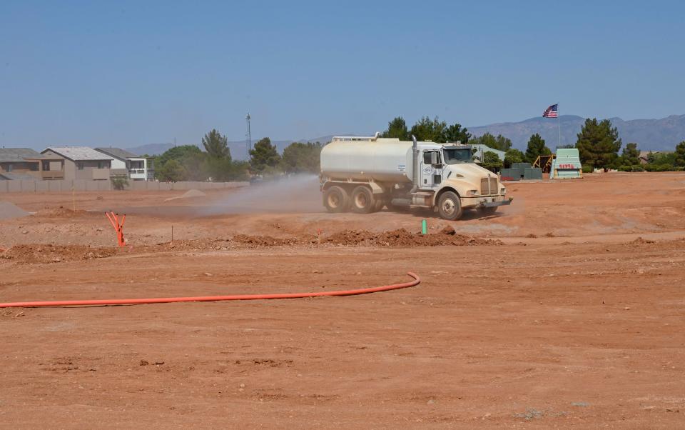 A truck sprays water to keep down dust in June 2021 at a construction site where homes are slated to be built in Sierra Vista, Arizona.