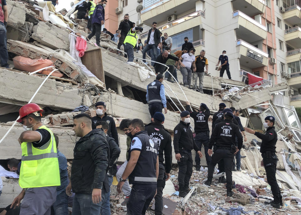 Rescue workers and local people try to save residents trapped in the debris of a collapsed building, in Izmir, Turkey, Friday, Oct. 30, 2020, after a strong earthquake in the Aegean Sea has shaken Turkey and Greece. Turkey's Disaster and Emergency Management Presidency said Friday's earthquake was centered in the Aegean at a depth of 16,5 kilometers (10.3 miles) and registered at a 6.6 magnitude.(AP Photo/Ismail Gokmen)