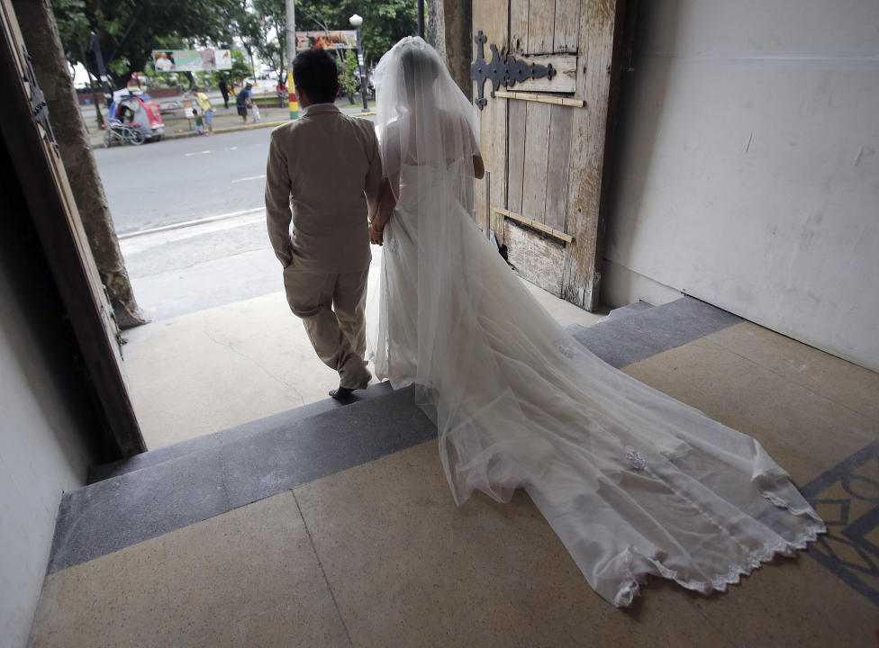 In this Jan. 8, 2015 photo, A Filipino couple walks out the door after their wedding at a Catholic church in Manila, Philippines. The Philippines is the only country in the world - aside from the Vatican - where divorce is forbidden, a testament to the enduring power of Roman Catholicism that has flourished since Spanish colonizers imposed it nearly 500 years ago. Visiting Pope Francis, the church and many of its followers in this Southeast Asian Catholic stronghold of 100 million believe strongly in the indissolubility of marriage. But a growing number of Catholics would support a change. (AP Photo/Aaron Favila)