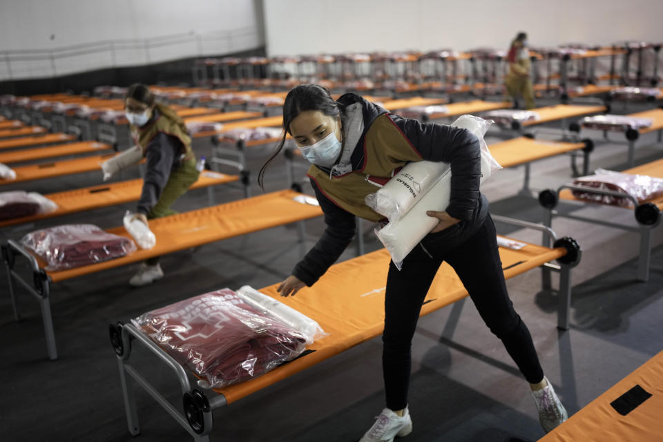 Members of the Portuguese Red Cross prepare cots at a sports hall converted to temporarily shelter Ukrainian refugees arriving in Lisbon, Thursday, March 3, 2022. The United Nations' refugee agency says 1 million people have fled Ukraine since Russia's invasion less than a week ago. (AP Photo/Armando Franca)