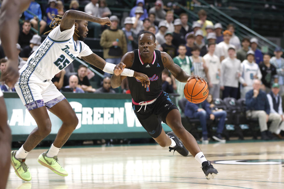 Florida Atlantic guard Johnell Davis (1) drives past Tulane guard Jaylen Forbes (25) during the first half of an NCAA college basketball game in New Orleans, Thursday, Jan. 11, 2024. (AP Photo/Tyler Kaufman)