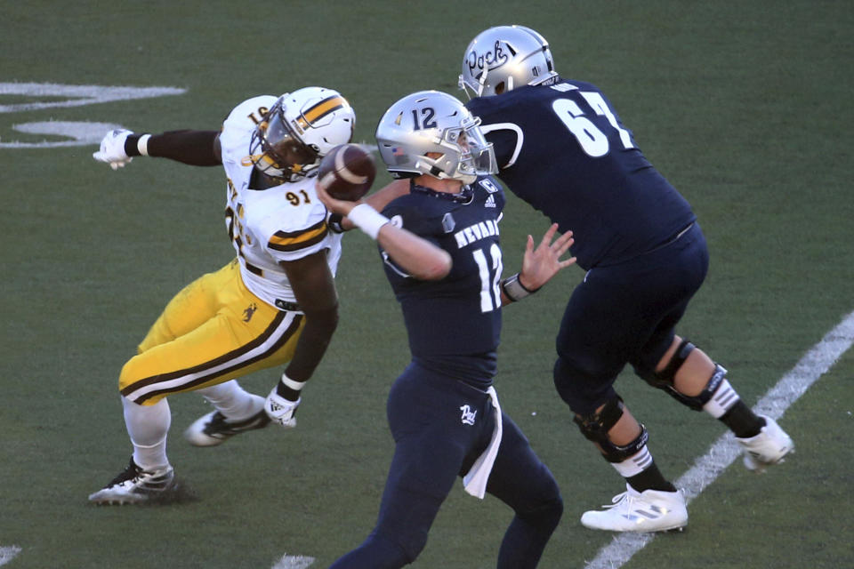 Nevada quarterback Carson Strong (12) throws a touchdown pass against Wyoming State during the first half of an NCAA college football game Saturday, Oct. 24, 2020, in Reno, Nev. (AP Photo/Lance Iversen)